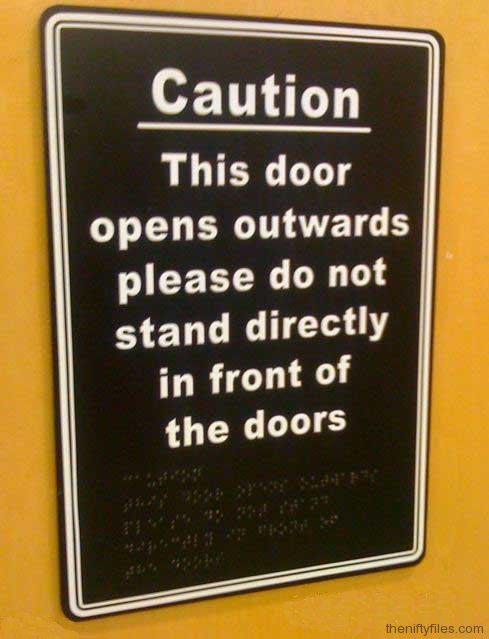 Sign warning not to stand in front of door to avoid injury also written in braille.